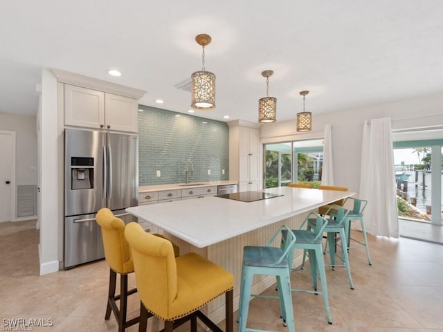 kitchen featuring appliances with stainless steel finishes, plenty of natural light, a sink, and tasteful backsplash