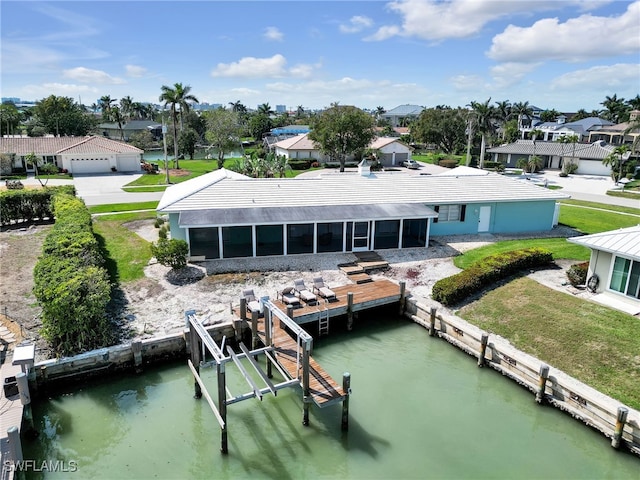 exterior space with a residential view, a water view, boat lift, and a sunroom