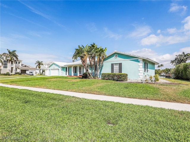 ranch-style home with a front lawn, an attached garage, and stucco siding