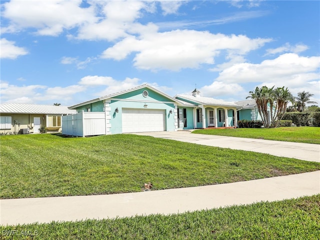 view of front of house featuring driveway, an attached garage, fence, and a front lawn