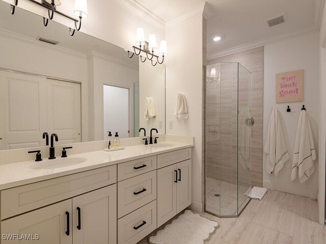 bathroom featuring a shower with shower door, vanity, and ornamental molding