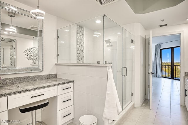 full bathroom with tile patterned flooring, visible vents, a shower stall, and vanity