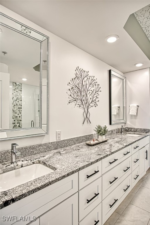 bathroom featuring a shower with shower door and vanity