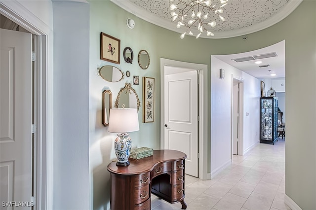 hallway with ornamental molding, light tile patterned flooring, visible vents, and baseboards