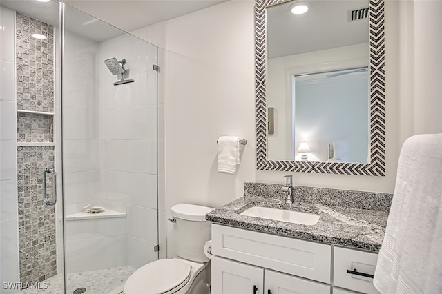 full bathroom featuring toilet, a shower stall, and vanity