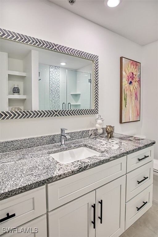 full bath with a stall shower and vanity