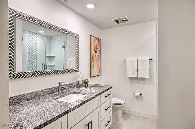 full bath with visible vents, baseboards, toilet, vanity, and a shower stall