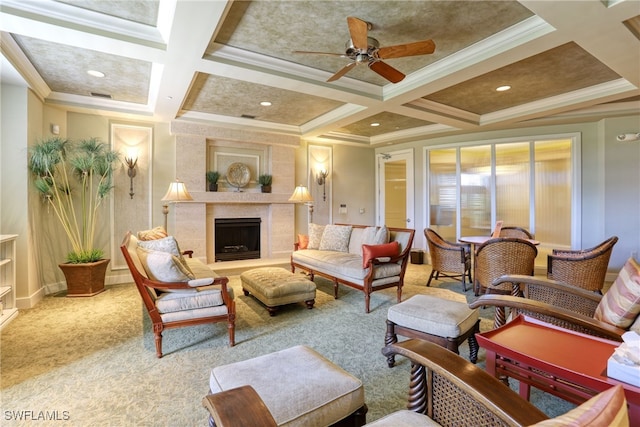 carpeted living room with a fireplace, coffered ceiling, a ceiling fan, baseboards, and crown molding