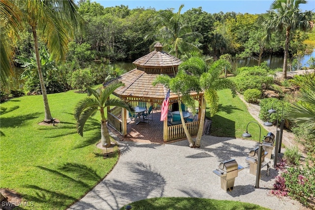 surrounding community featuring a gazebo, a yard, a forest view, and a water view