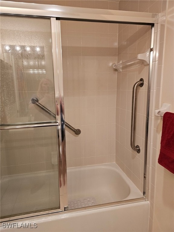 bathroom featuring combined bath / shower with glass door