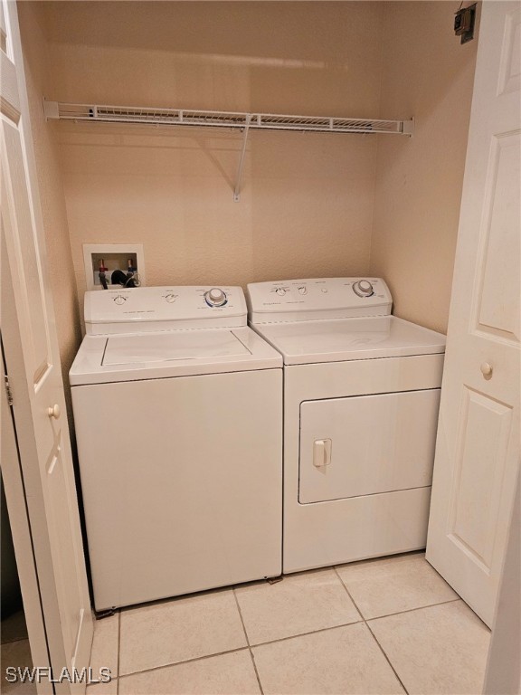 laundry area featuring washing machine and dryer and light tile patterned floors