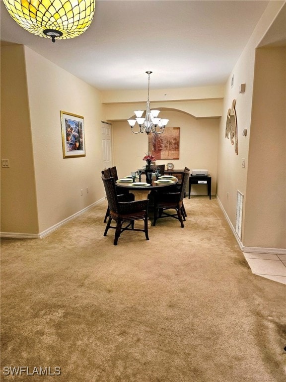 dining room with a notable chandelier and carpet