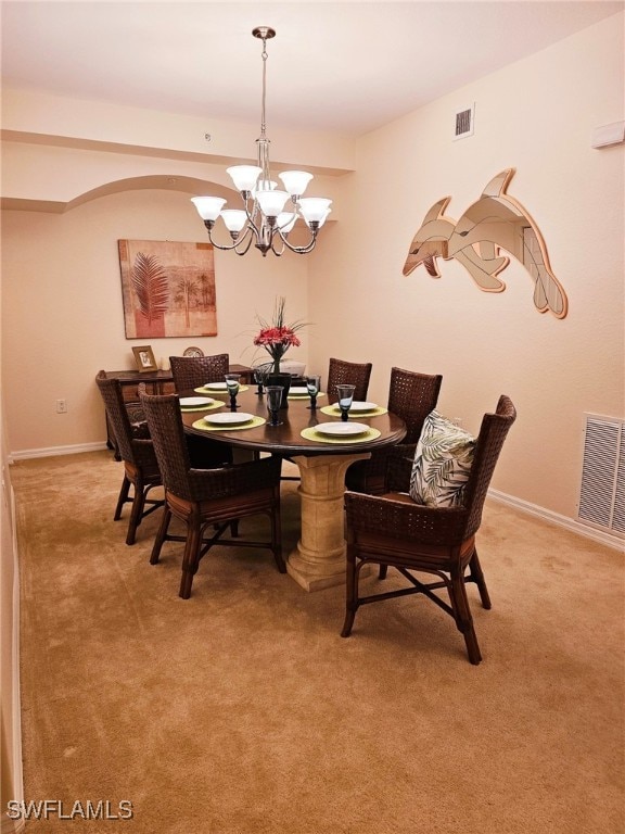 dining room with carpet floors and an inviting chandelier