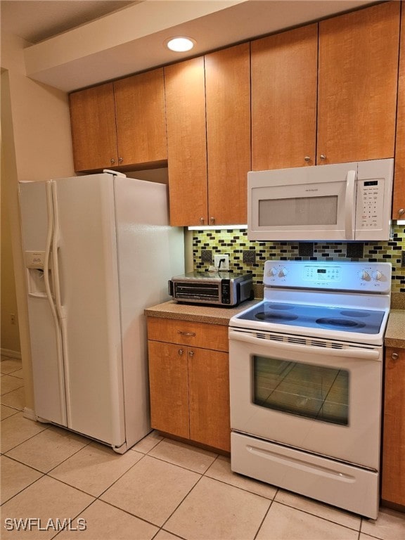 kitchen featuring white appliances, backsplash, and light tile patterned floors