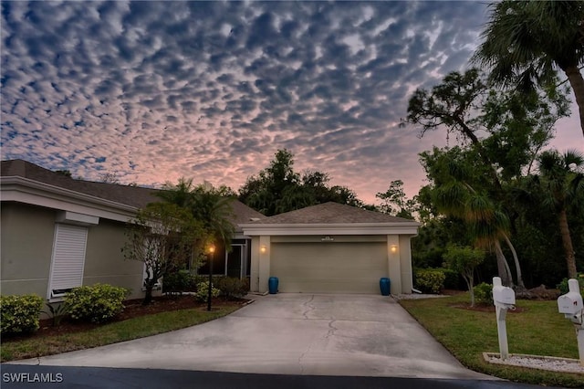 view of front of house with a garage and a lawn