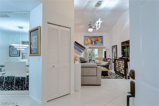 interior space with light tile patterned floors and ceiling fan