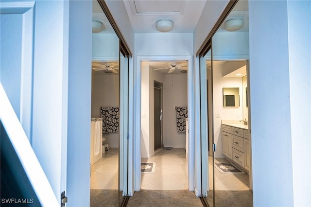 hall with light colored carpet and sink