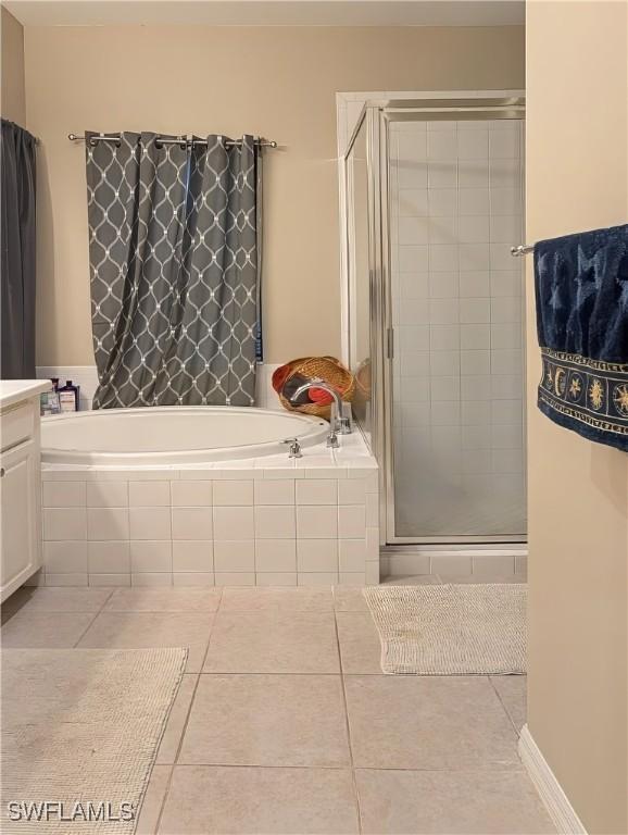 bathroom with tile patterned flooring, shower with separate bathtub, and vanity