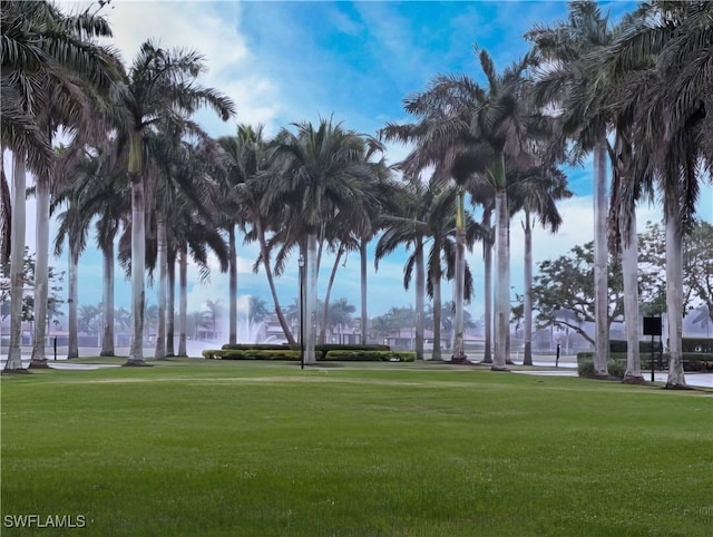 surrounding community with a lawn and a water view