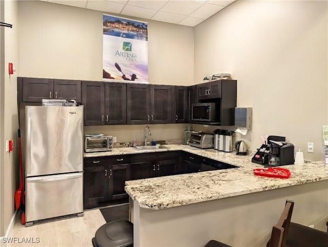 kitchen featuring a breakfast bar, kitchen peninsula, sink, and stainless steel appliances