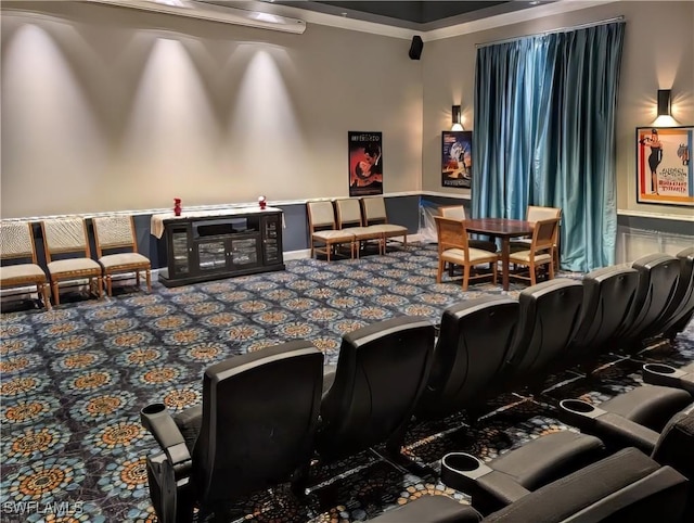 carpeted cinema room featuring crown molding