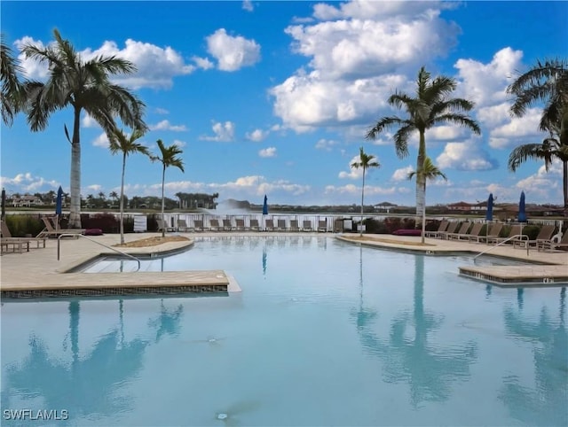 view of pool with a patio area and a water view