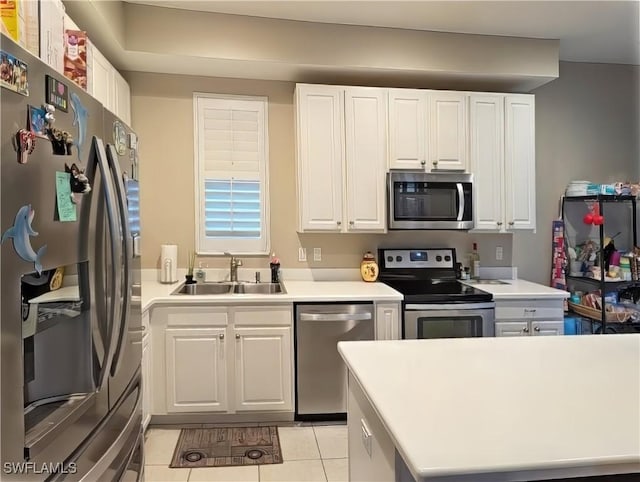 kitchen featuring sink, white cabinetry, light tile patterned floors, and stainless steel appliances