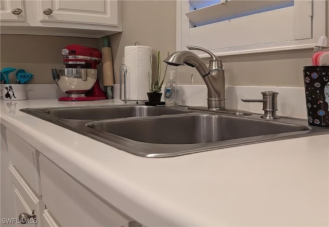 details featuring white cabinets and sink