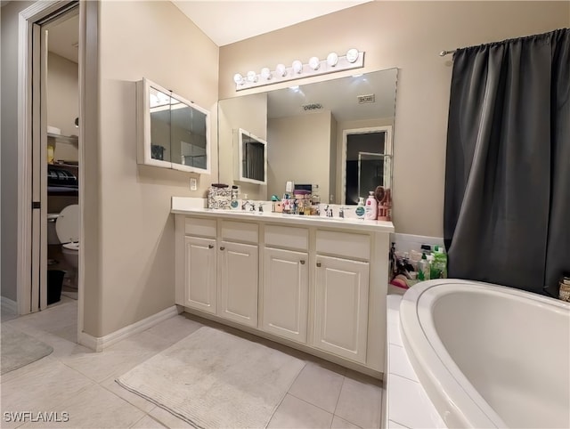 bathroom featuring tiled tub, tile patterned floors, vanity, and toilet