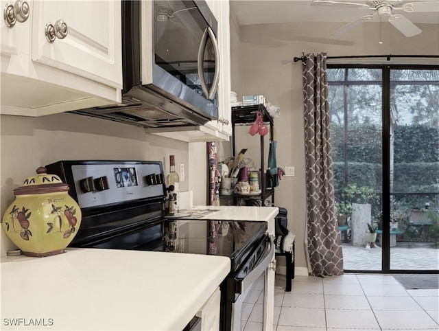 kitchen with light tile patterned flooring, ceiling fan, appliances with stainless steel finishes, and white cabinets