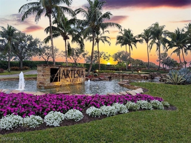 community / neighborhood sign with a water view and a yard