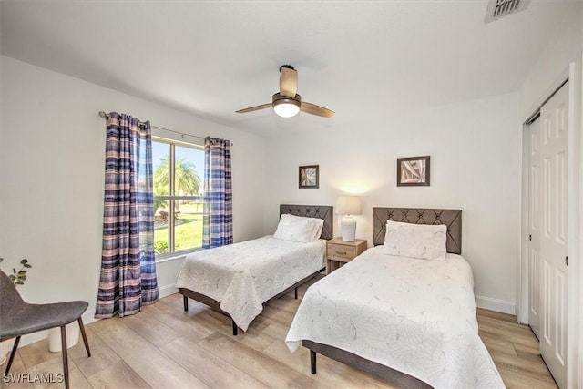 bedroom with ceiling fan, a closet, and light hardwood / wood-style floors