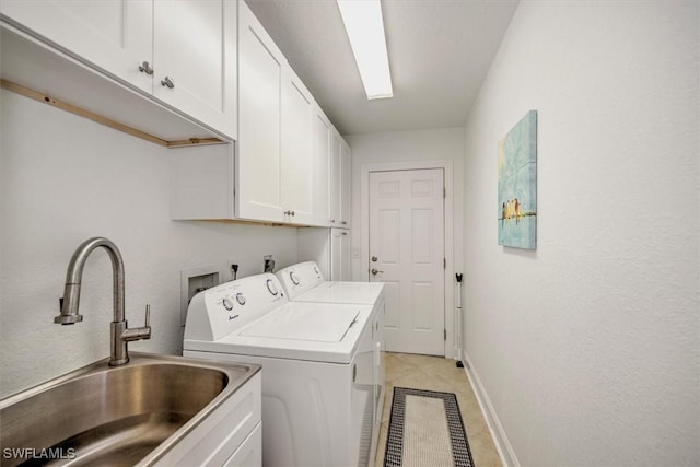 washroom with washer and dryer, sink, light tile patterned floors, and cabinets