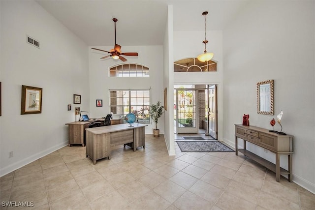 entrance foyer with a towering ceiling, ceiling fan, and light tile patterned floors