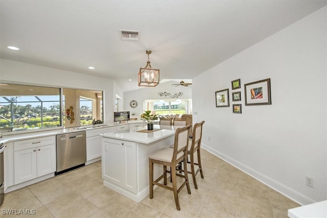 kitchen with stainless steel dishwasher, pendant lighting, a kitchen island, white cabinetry, and ceiling fan with notable chandelier