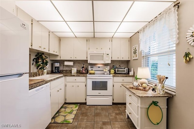 kitchen featuring sink, a drop ceiling, tasteful backsplash, white appliances, and white cabinets