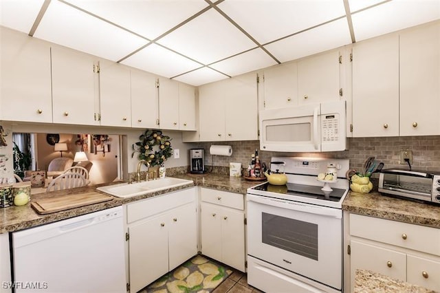 kitchen with decorative backsplash, sink, white cabinets, and white appliances