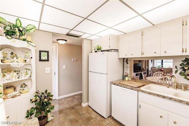 kitchen with a paneled ceiling, white cabinetry, white appliances, and sink