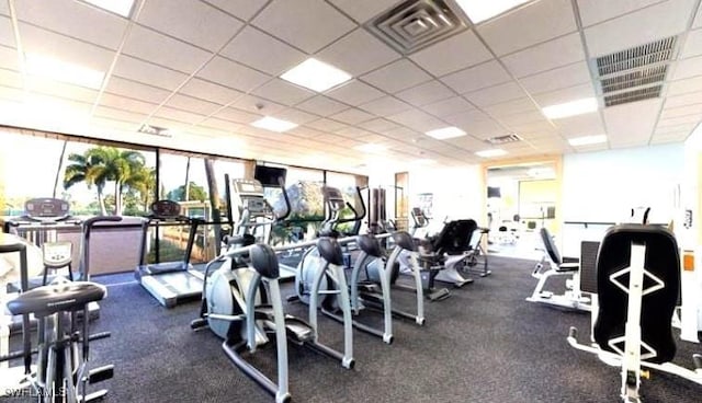 gym with a drop ceiling and expansive windows