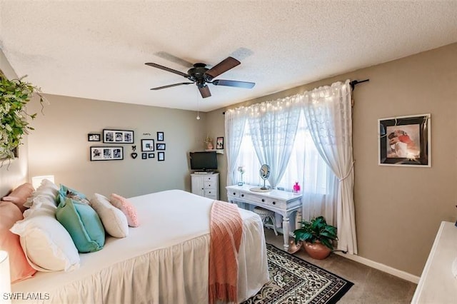 bedroom featuring ceiling fan, carpet, and a textured ceiling