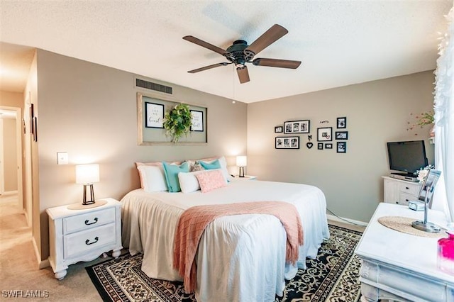 carpeted bedroom featuring a textured ceiling and ceiling fan