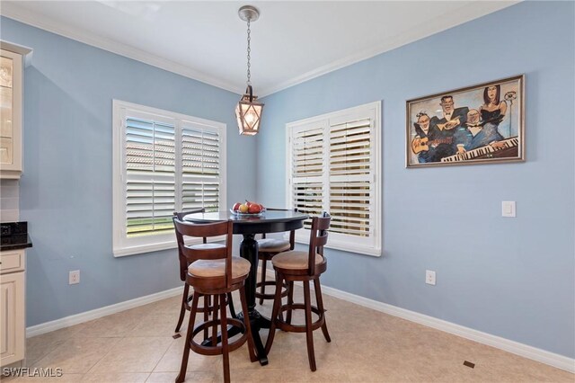 dining area featuring ornamental molding and light tile patterned floors