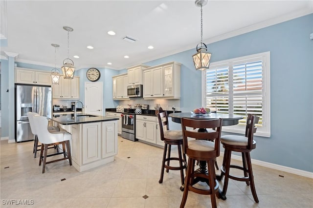 kitchen featuring dark countertops, appliances with stainless steel finishes, hanging light fixtures, cream cabinets, and crown molding