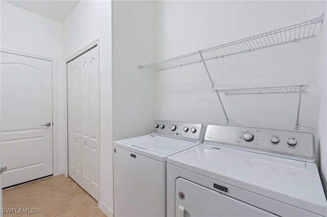 washroom with light tile patterned floors and washer and clothes dryer