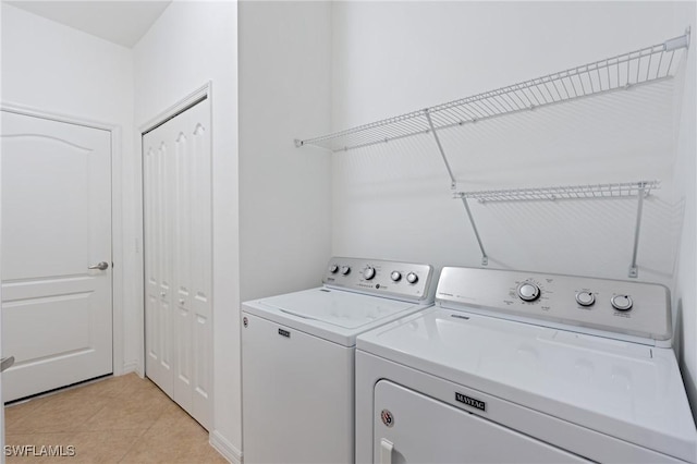 washroom with washing machine and dryer, laundry area, and light tile patterned flooring