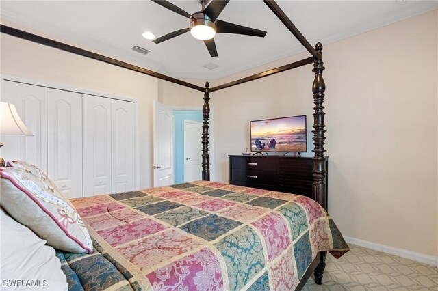 carpeted bedroom with a closet, ceiling fan, and crown molding