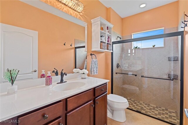 bathroom featuring tile patterned flooring, an enclosed shower, vanity, and toilet