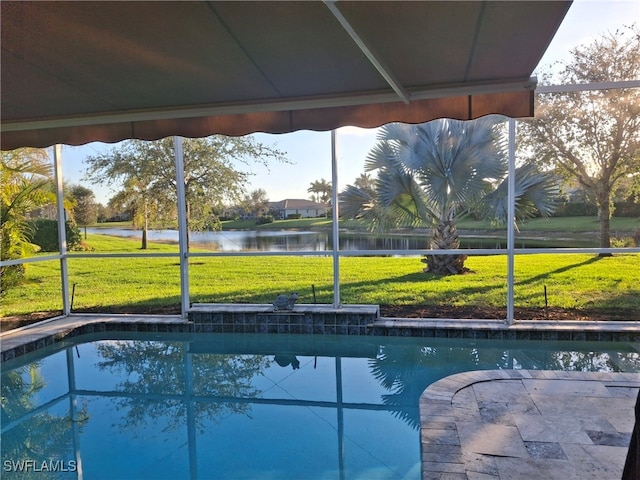 outdoor pool with a water view and a lawn