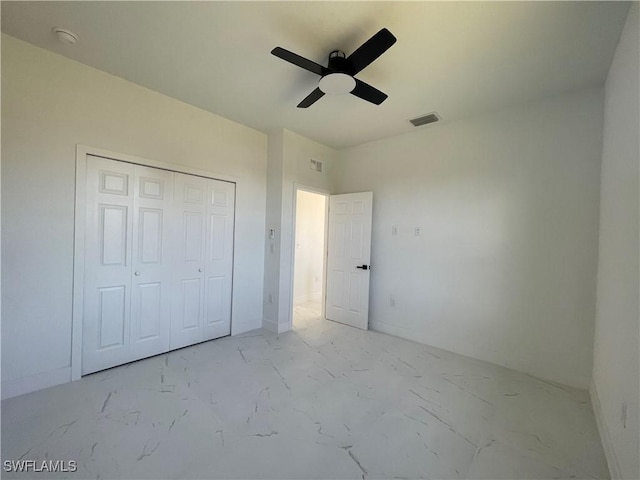 unfurnished bedroom with ceiling fan and a closet