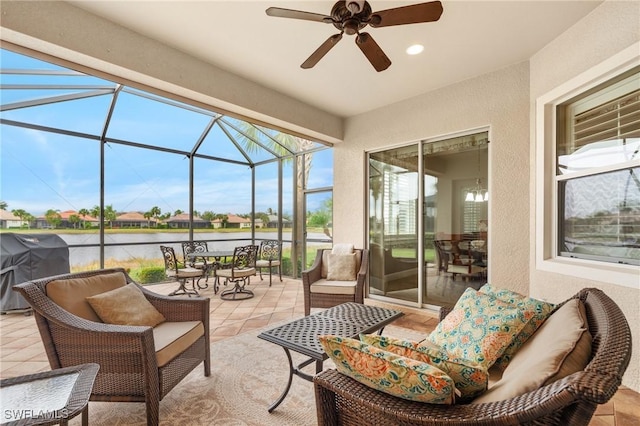 sunroom with a water view and ceiling fan